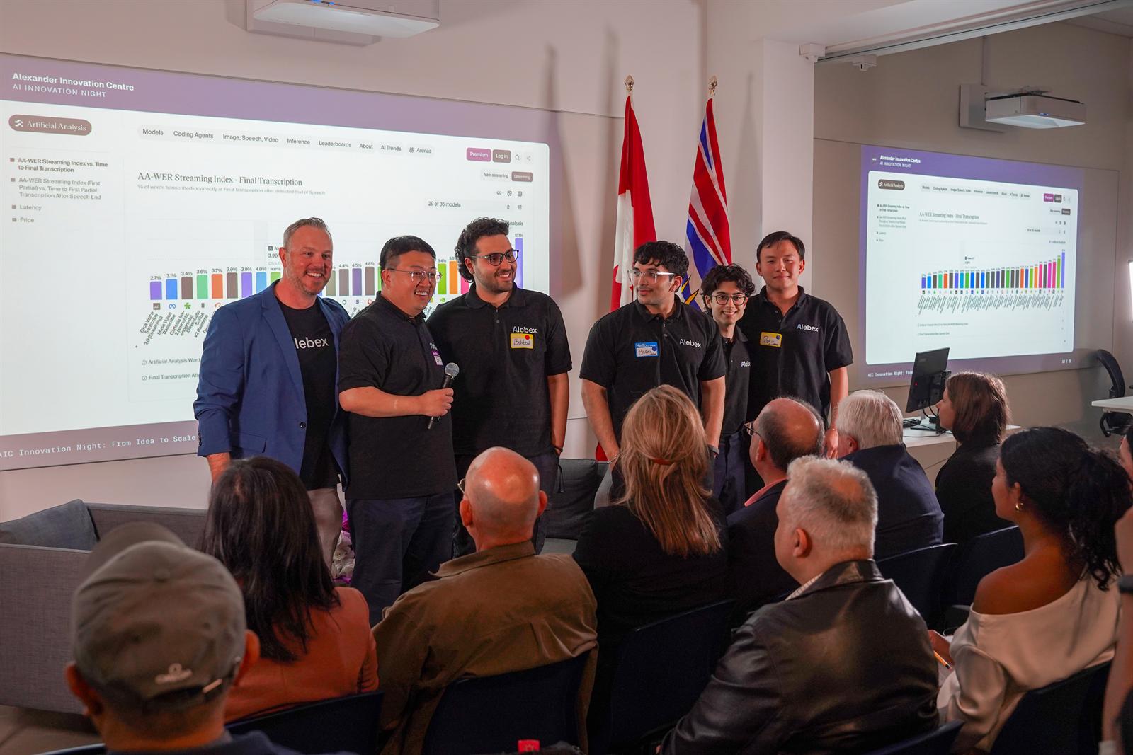 The Alebex team presenting at Alexander Innovation Centre's AI Innovation Night, with the Artificial Analysis AA-WER Streaming Index leaderboard projected behind them.