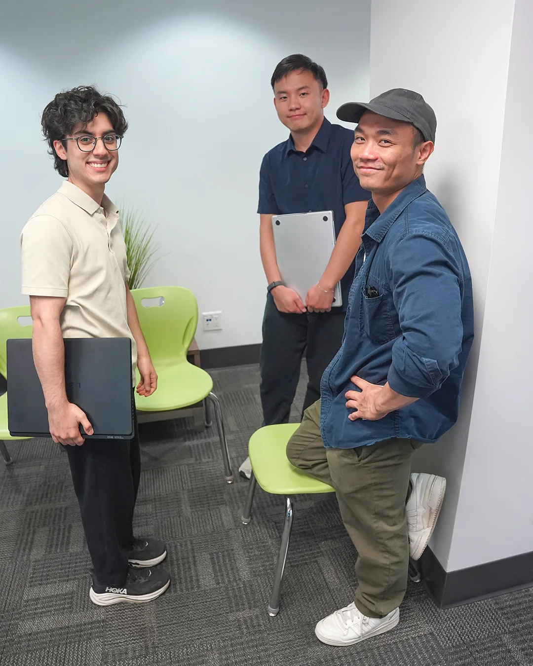 Three participants posing together with their laptops.