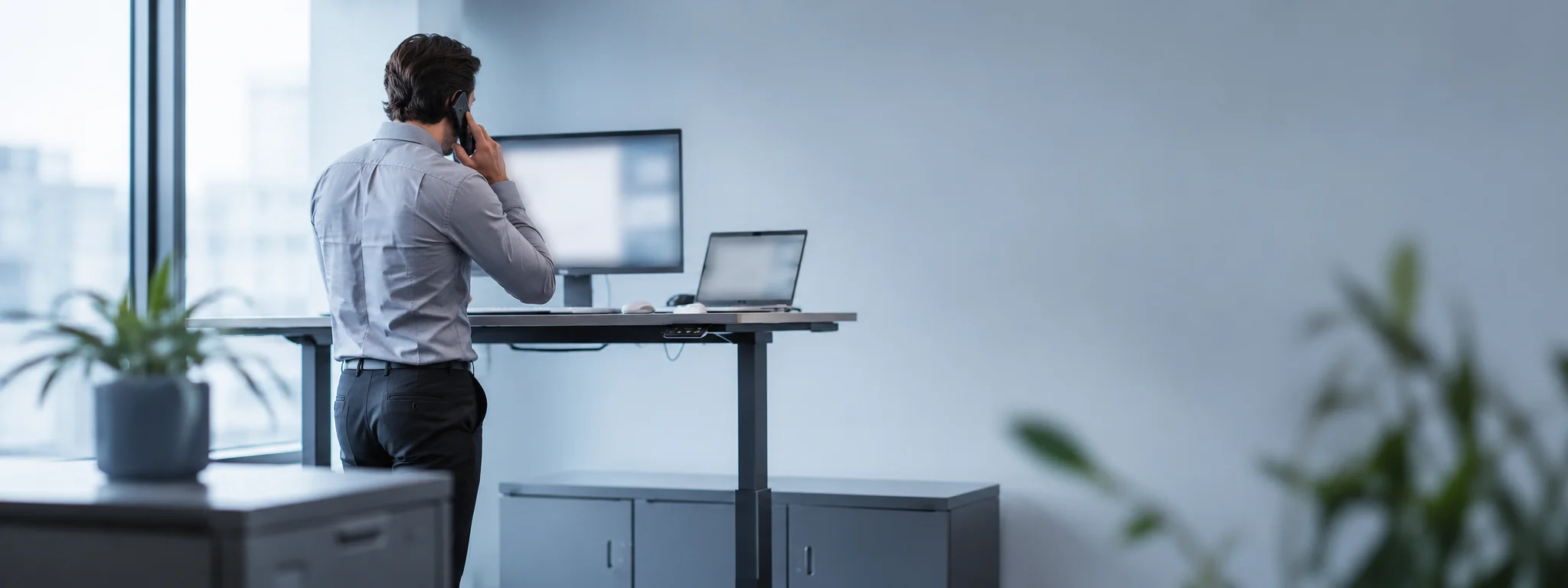 Recruiter on a call at a standing desk, cool office light